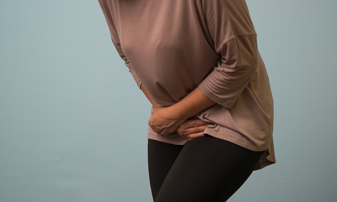 Woman with hands over bladder